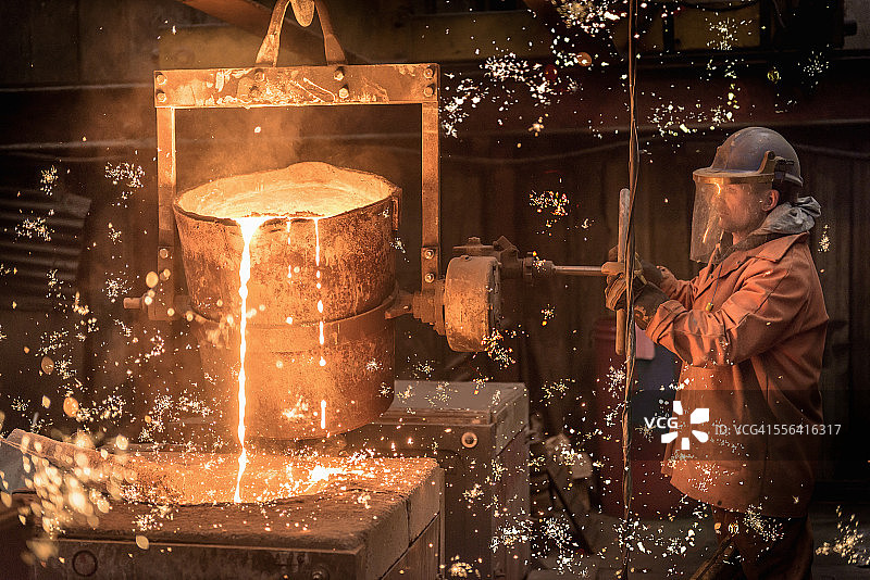 工人在铸造厂倾倒熔化的金属图片素材