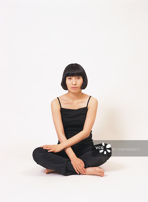 一个交叉双腿坐着的年轻女子图片素材