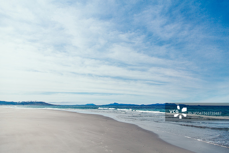 朦胧的云笼罩在一个僻静的海滩上图片素材