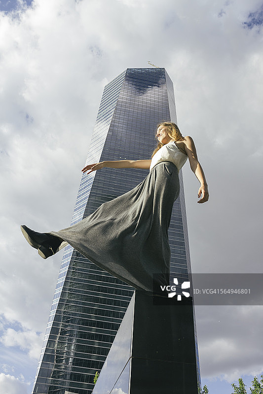 西班牙，马德里，摩天大楼前墙上的年轻女子图片素材