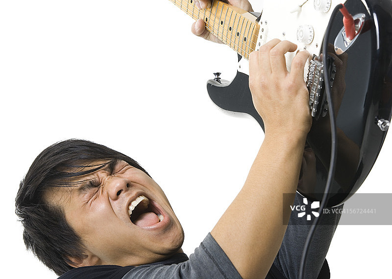 一个年轻人在弹电吉他的特写图片素材