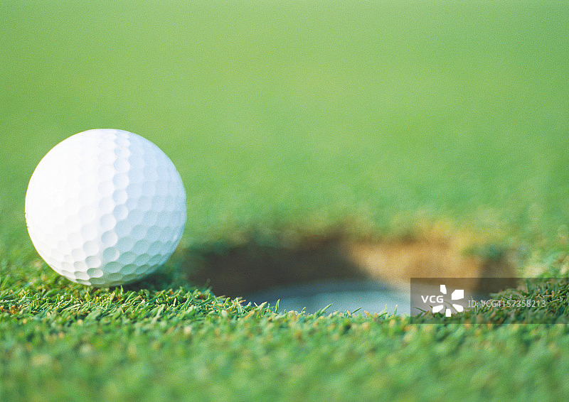 高尔夫球在洞的边缘，特写图片素材