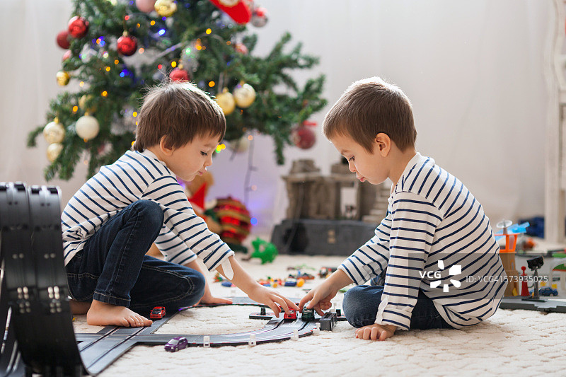 两个可爱的男孩，在圣诞节玩玩具图片素材