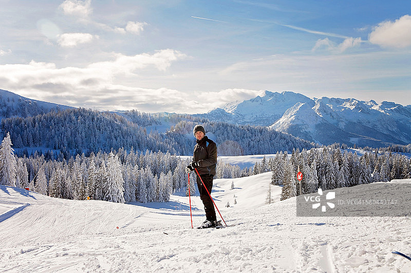 年轻的滑雪者在冬天的山顶图片素材