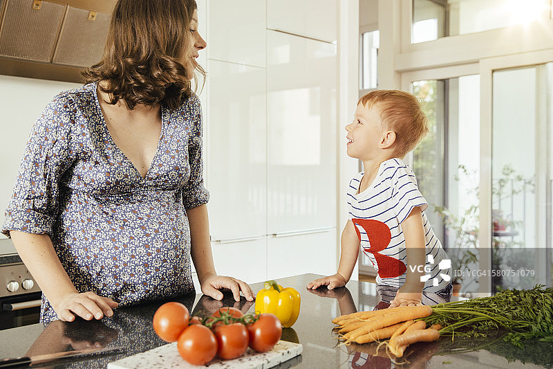 一个孕妇和她的小儿子在厨房里图片素材