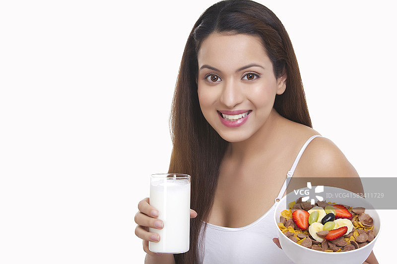 一个女人的肖像，拿着一杯牛奶和麦片图片素材