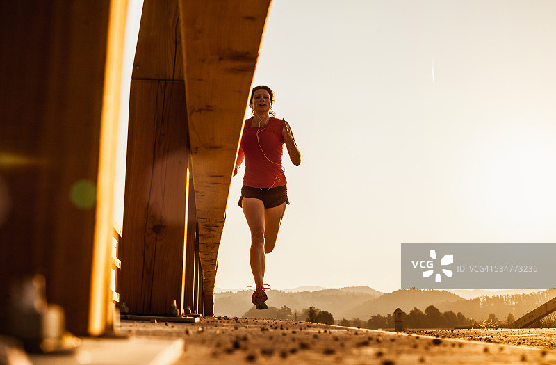 日落时分在户外跑步的年轻女子图片素材