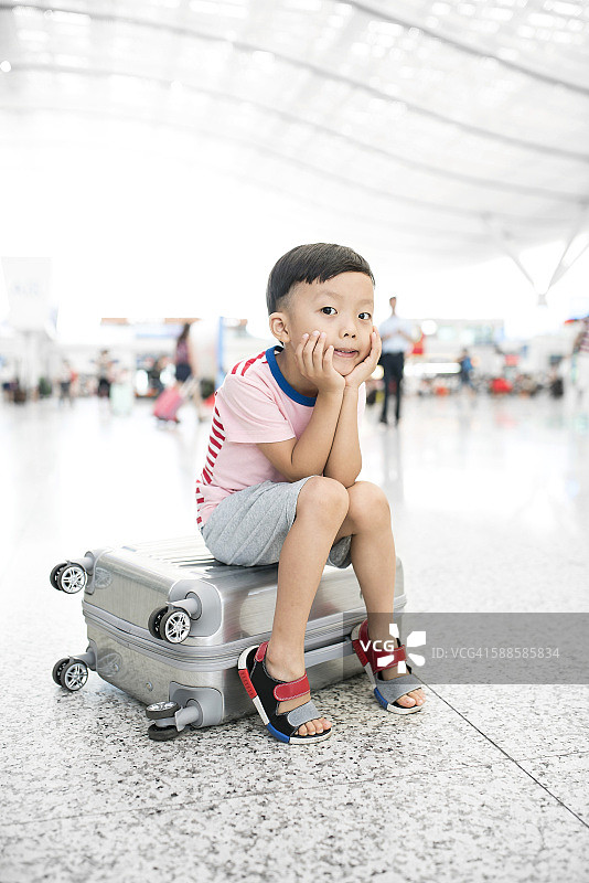可爱的小男孩在机场等着，孩子旅行图片素材