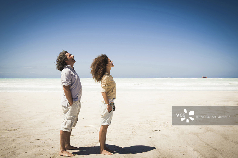 一对夫妇站在沙滩上迎风而行图片素材