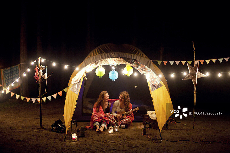 女孩们晚上在露营帐篷里放松图片素材
