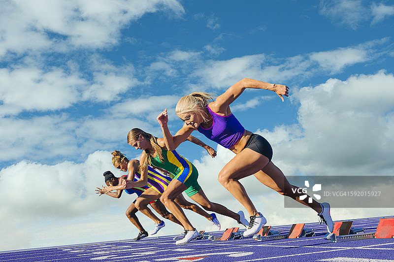 四名女运动员在田径跑道上，离开起跑点图片素材