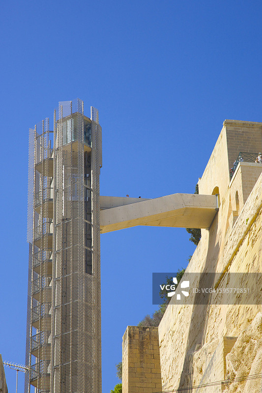 现代钢电梯结构附在石墙上图片素材
