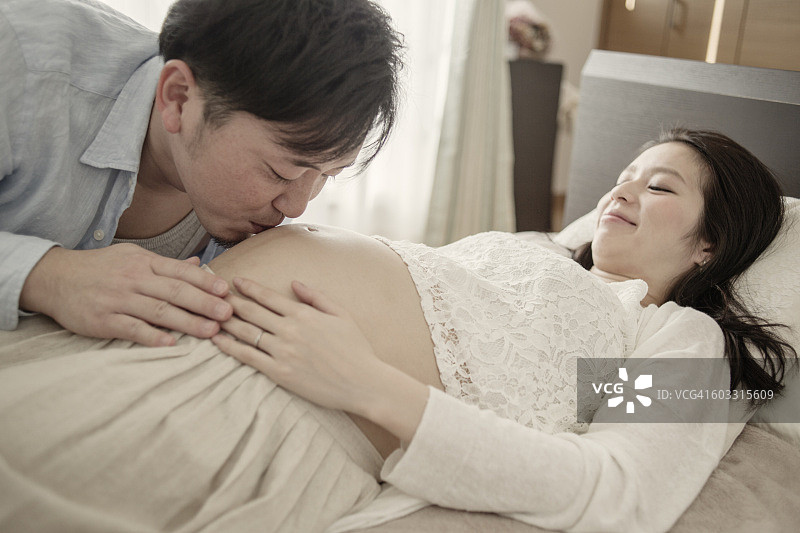 丈夫亲吻孕妇的肚子图片素材