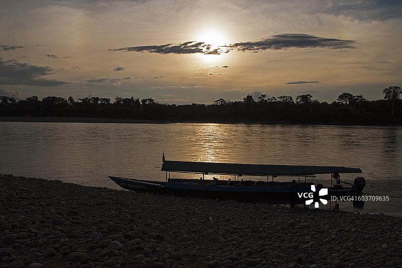 在秘鲁的亚马逊，坦波帕塔河，坦波帕塔国家保护区，坦波帕塔省，马德雷德迪奥斯地区，秘鲁，在日落的轮廓亚马逊小艇。图片素材