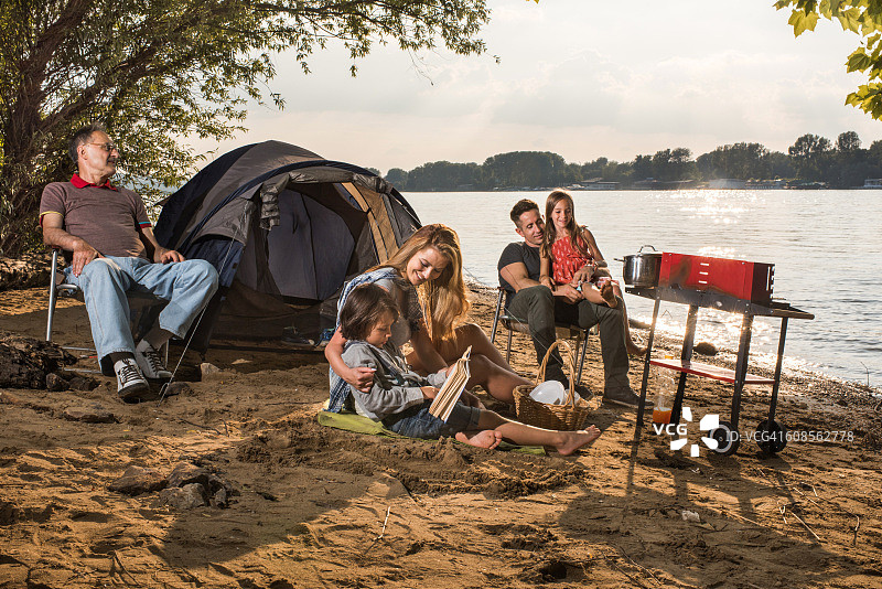 几代同堂的家庭在河边露营放松。图片素材