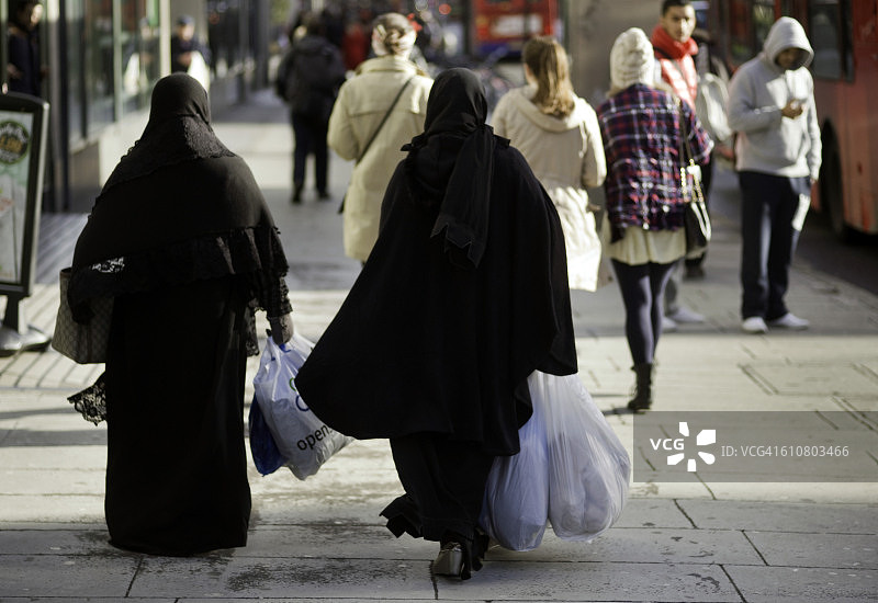 欧洲，英国，英国，伦敦，两个穆斯林妇女穿着布卡巡游Edgware路携带塑料射击袋图片素材