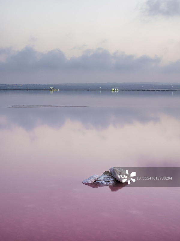 在一个粉红色咸水的泻湖上，在一个小岛上平静的水里变黑图片素材