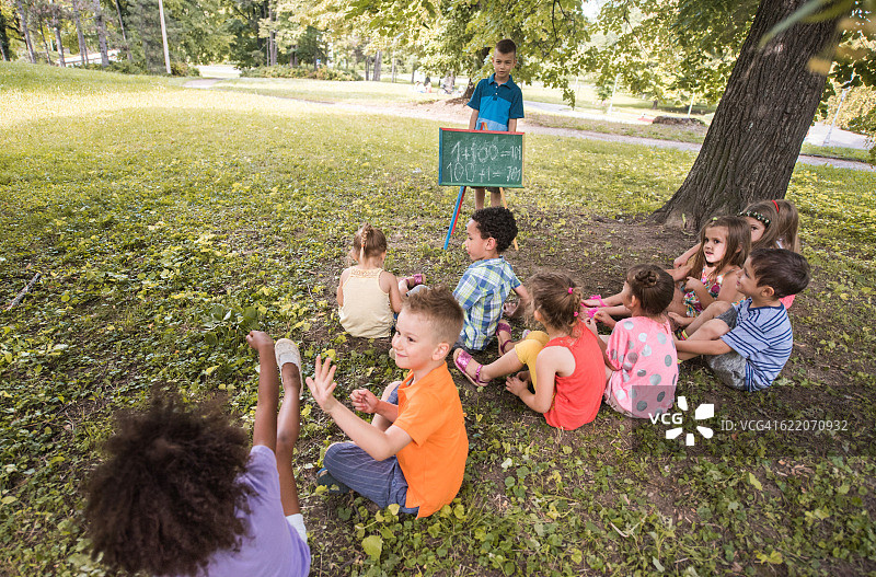 一群小朋友在公园里学习数学。图片素材