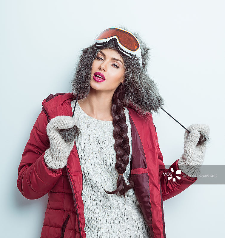 性感的女人在冬天的装备-羽绒服，皮草帽子图片素材