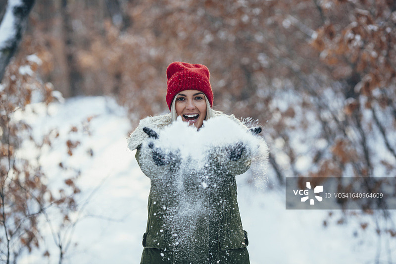 快乐的年轻女子玩雪的肖像图片素材