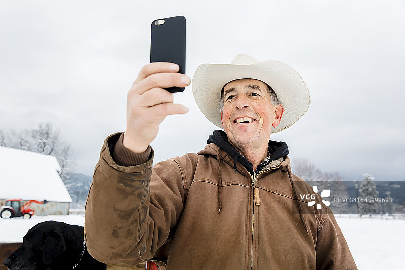 白人农民在雪地里使用手机图片素材