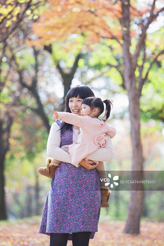 日本母女欣赏秋天的落叶图片素材