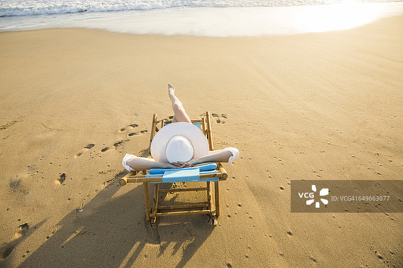 一个白人女人躺在沙滩上图片素材