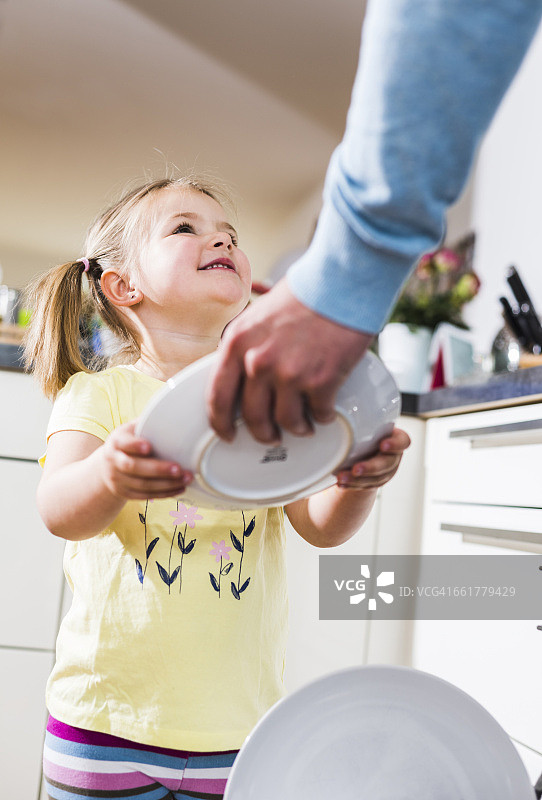 女儿帮助父亲清理洗碗机图片素材