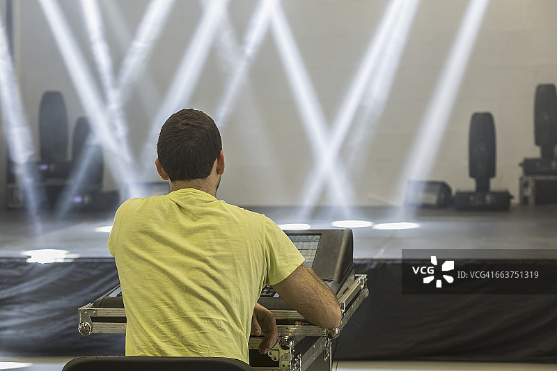 人与声音混音器坐在背对照明舞台的后视图图片素材