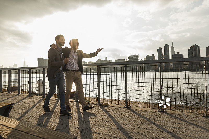 在美国纽约市，两个商人沿着东河散步图片素材