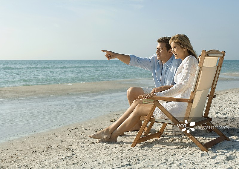 一对夫妇坐在沙滩上的躺椅上图片素材