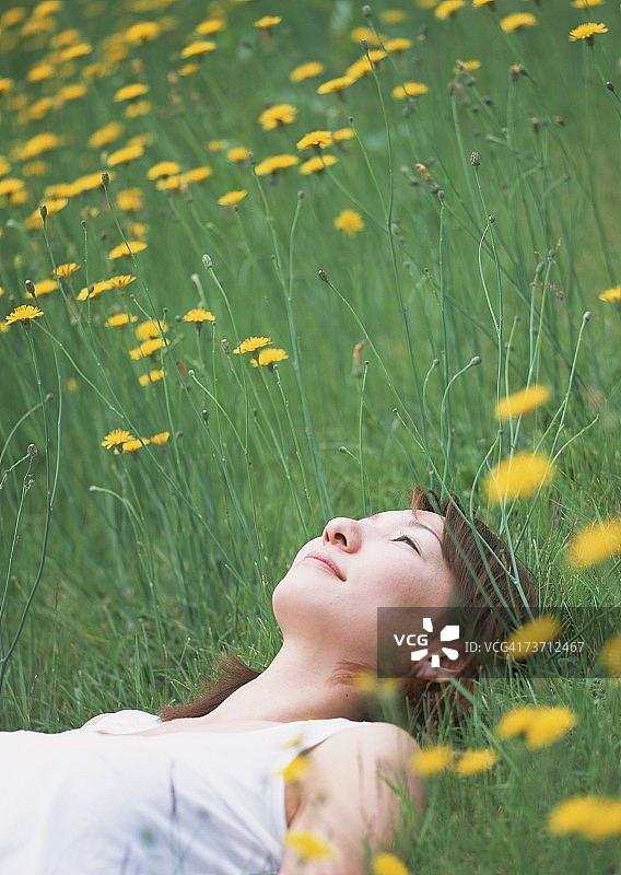 年轻女子躺在田野里图片素材