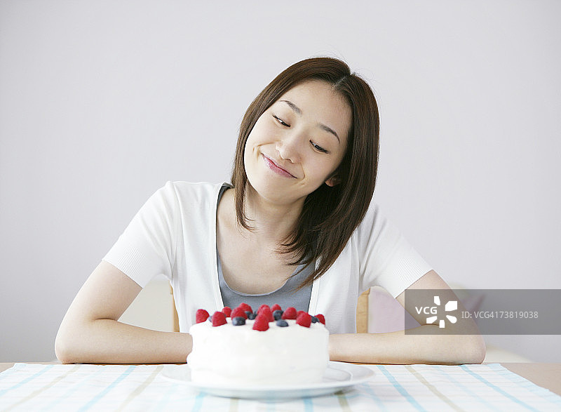 一个日本女人在蛋糕前微笑图片素材