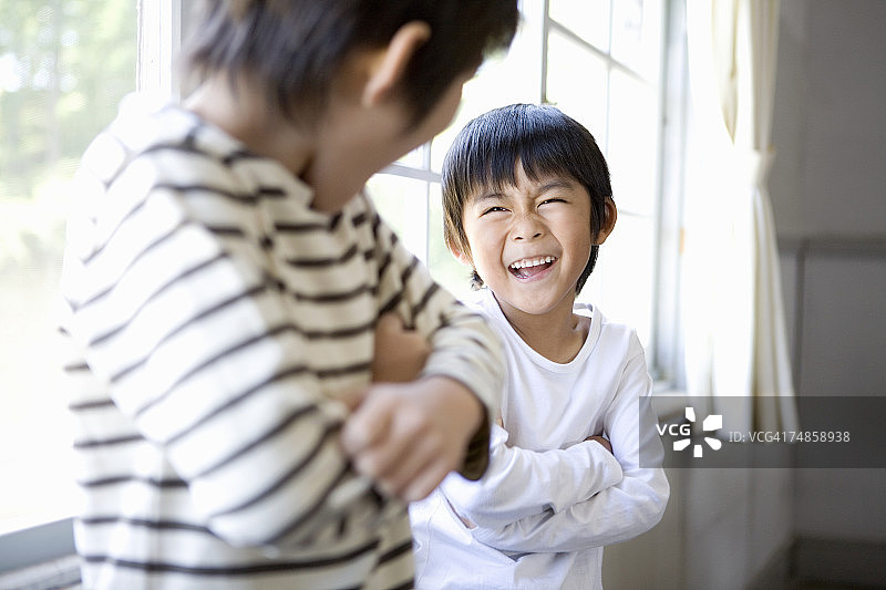 两个男孩(5-7)在教室里笑图片素材