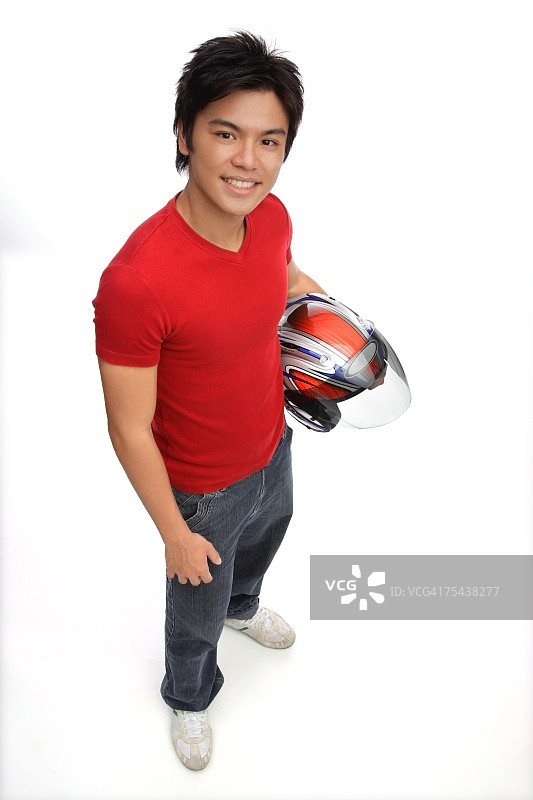 戴着摩托车头盔的年轻人，对着镜头微笑图片素材