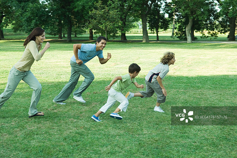 "全家户外，一起在草地上奔跑"图片素材