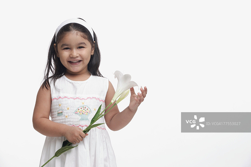 年轻的女孩穿着白色的衣服，拿着一朵花图片素材