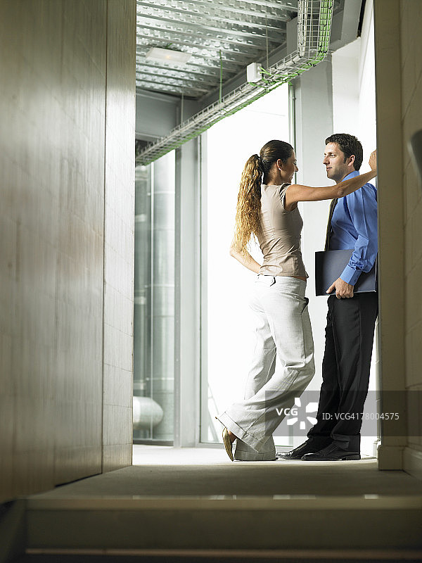 一个女人在走廊里和一个男人说话图片素材