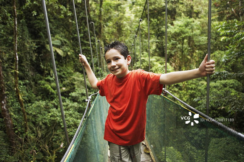 在荒野地带，男孩站在桥上图片素材
