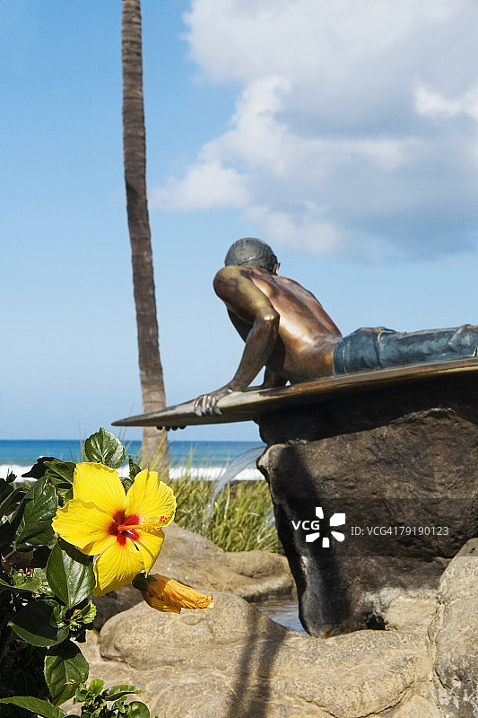 一个男人的雕像躺在冲浪板上，威基基海滩，檀香山，瓦胡岛，夏威夷群岛，美国图片素材
