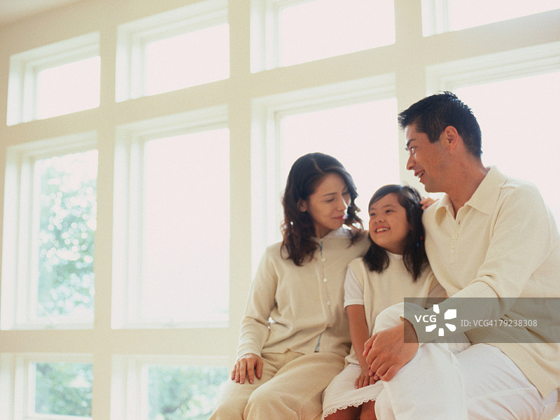 爸爸，妈妈和女儿坐在窗台边图片素材
