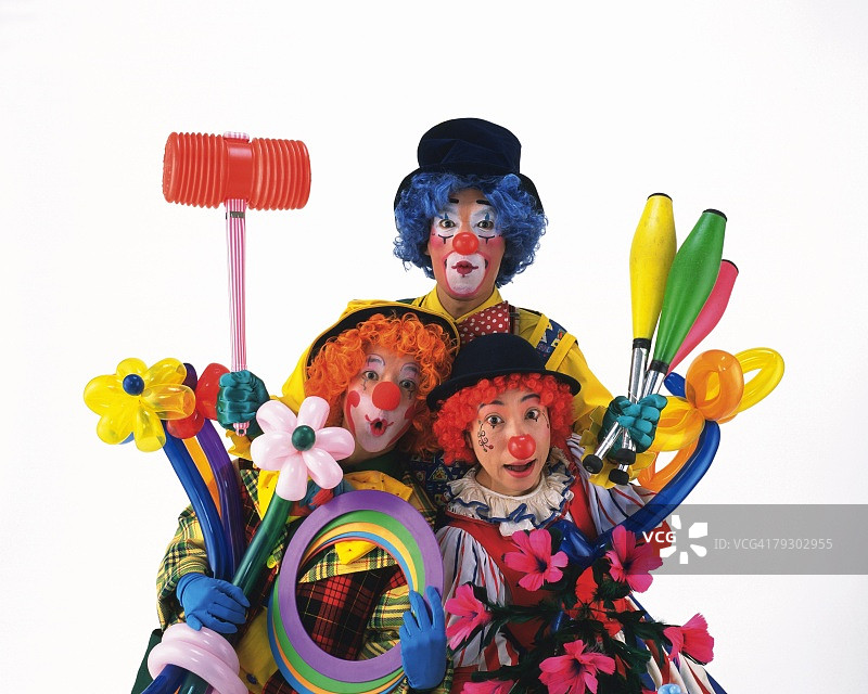 小丑的肖像拿着花气球，纸环，俱乐部和锤子，正面视图图片素材