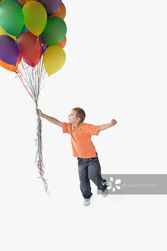 一个小男孩拿着一堆气球图片素材