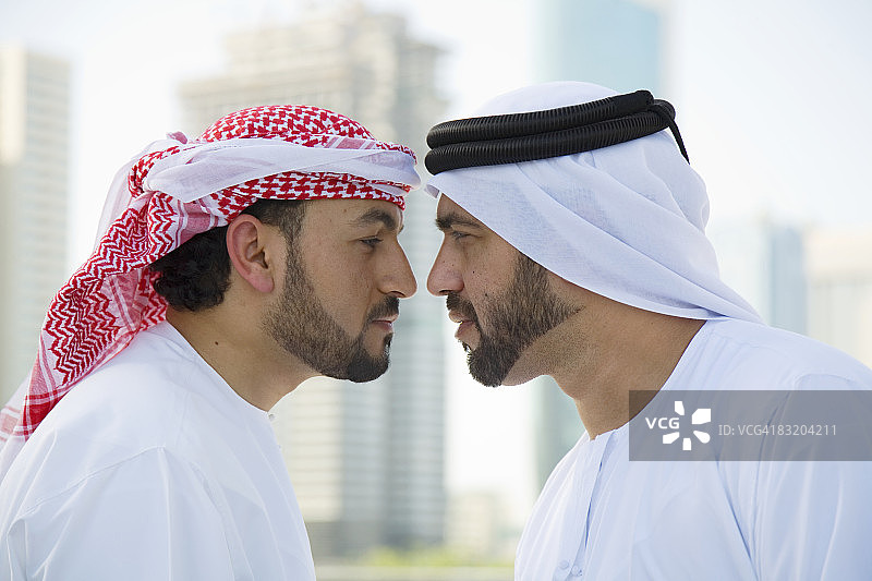 两名身着中东服饰的男子在阿联酋迪拜互相问候图片素材