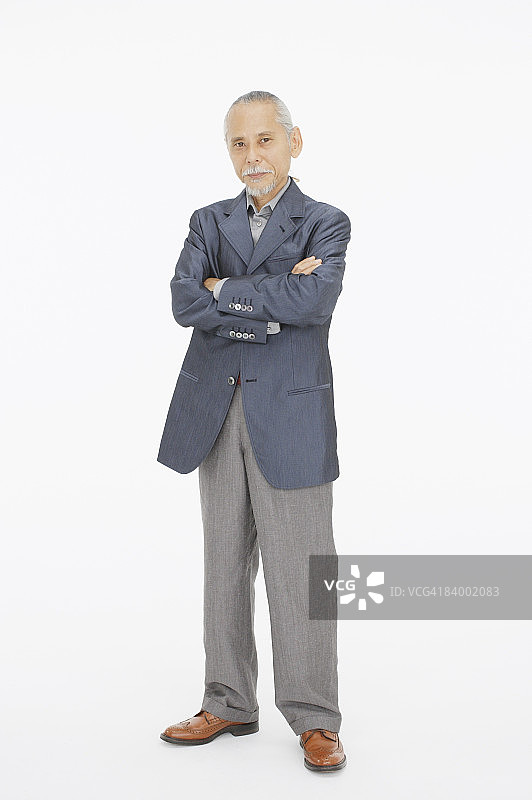 一位双臂交叉的老人的肖像，在摄影棚拍摄图片素材