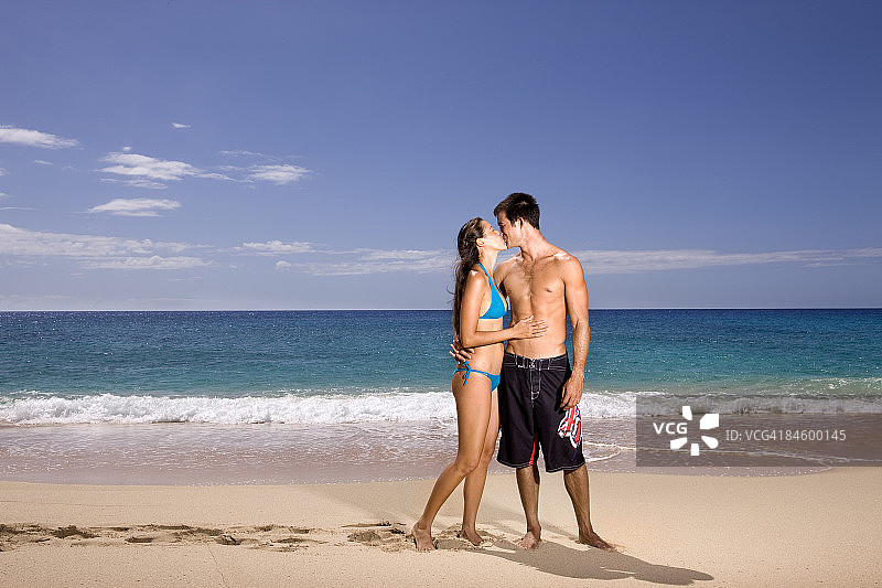 一对年轻情侣在海滩上接吻图片素材