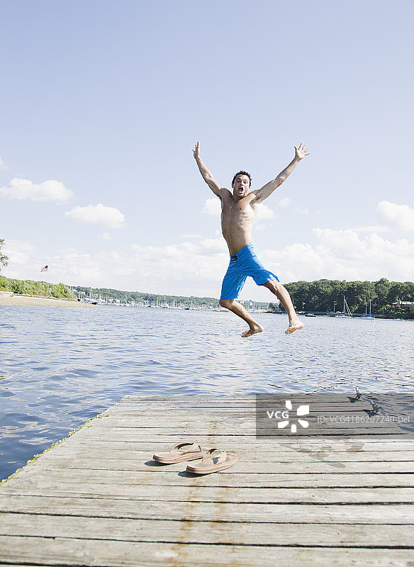 一幅男子从码头跳入湖中的画像图片素材