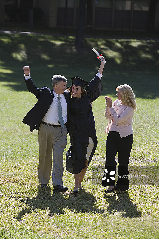 毕业典礼上和父母在一起的女人图片素材