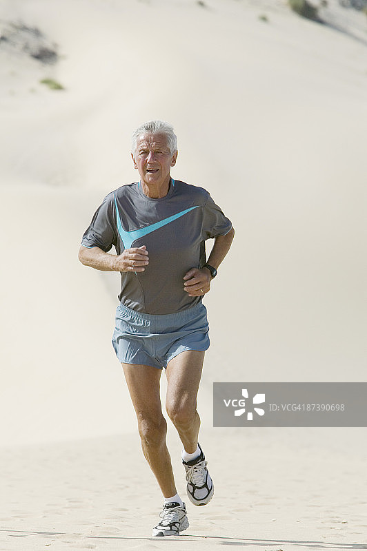 成熟的男人在沙滩上奔跑图片素材