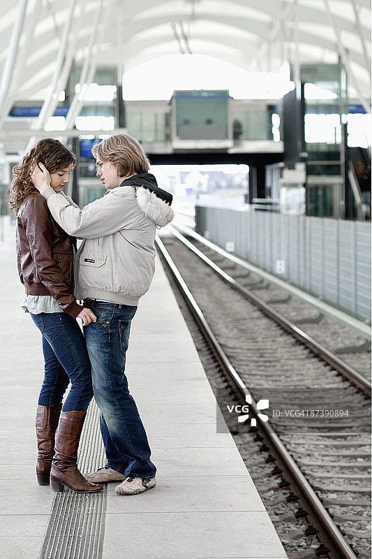 一对悲伤的青少年情侣在车站拥抱图片素材